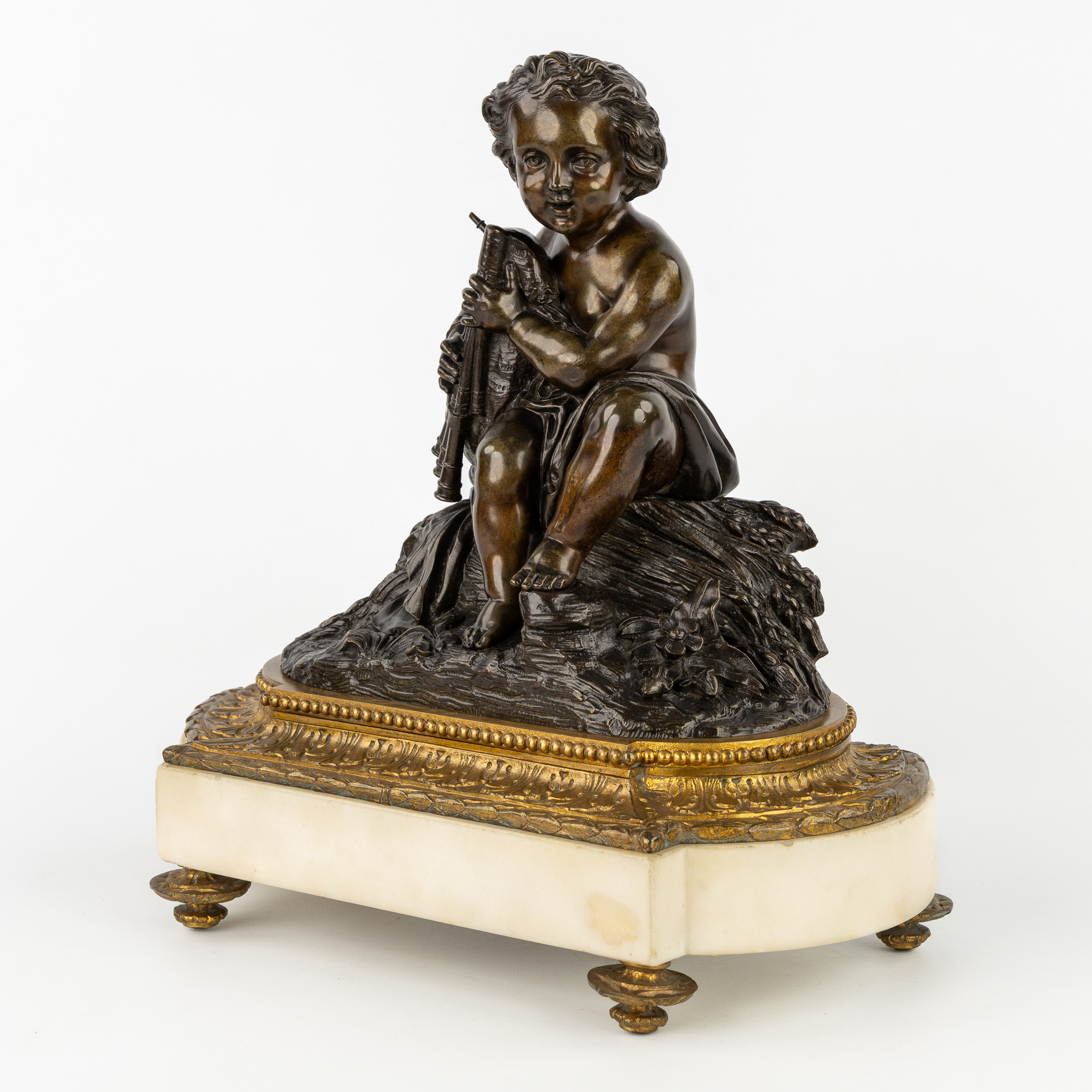 Een sculptuur van een putto met doedelzak, Allegorie van de Zomer, gepatineerd en verguld brons op een marmeren sokkel. (L:33 x W:17.5 x H:34 cm)